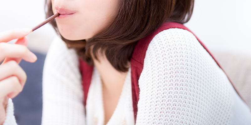 ポッキーをたべる女性